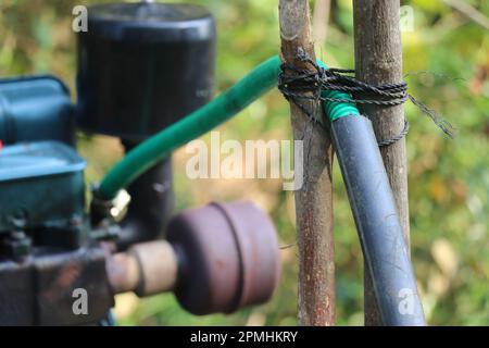 Ansicht eines Rohrs, das während der Verbrennung eines Dieselmotors, der eine Zentrifugalwasserpumpe betreibt, heißes Wasser aus dem Zylinderkopf leitet Stockfoto