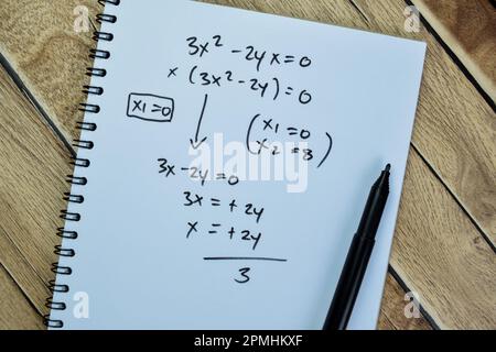 Konzept von Mathematikformeln, die auf Buch geschrieben werden, isoliert auf Holztisch. Stockfoto