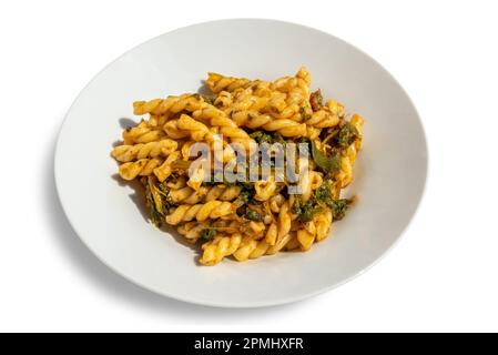 Fusilli-Pasta mit Rüben, typisch italienisches Rezept aus Apulien, in weißer Platte isoliert auf weißem Boden mit Schnittpfad Stockfoto