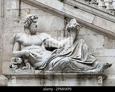 Eine Statue des flussgottes Tiber (Tiberinus) steht hoch auf der großen Piazza del Campidoglio von Rom, mit ihrer mächtigen und muskulösen Figur Stockfoto