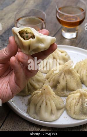 Wie man georgische Khinkali-Klöße isst Stockfoto