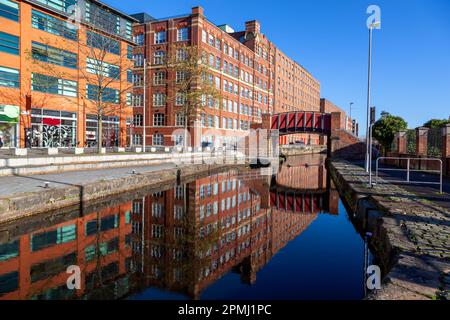 Spiegelung von Footbridge und Lagern in Murray Mills Redhill Street Ancoats Manchester UK Stockfoto