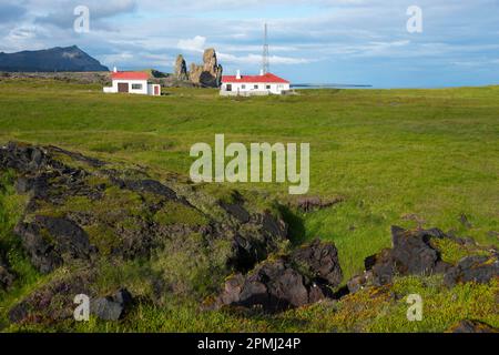 Häuser und Londrangar, Basaltfelsen in der Nähe von Malarrif, Snaefellsnes Halbinsel, Island Stockfoto