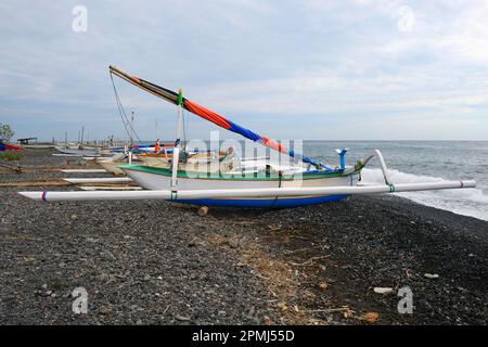 Traditionelle farbenfrohe Outrigger-Boote am schwarzen Lava-Strand von Lovina, Nordbali, Bali, Indonesien Stockfoto