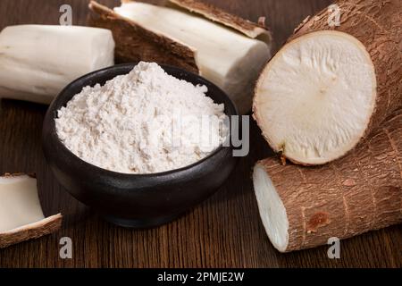 Rohe Kassava-Wurzel Und Stärke – Maniok-Esculenta; Auf Holzhintergrund Stockfoto