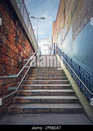 Außentreppe hinter den Gebäudewänden. Abstrakte Aussicht oben, Straßenszene Stockfoto