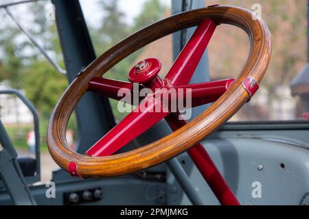 Altes Holz- und Metalllenkrad in einem Oldtimer-Traktor Stockfoto