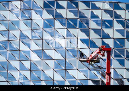 Gebäudereiniger reinigen Fensterscheiben, reinigen eine Fassade, Lkw-Arbeitsplattform der deutschen Vermietungsfirma Gerken, Gebäude der Hafenbehörde Antwerpen, Stockfoto