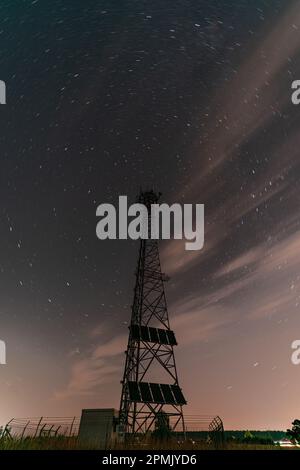 Eine atemberaubende Nachtaufnahme einer Silhouette des Funkturms unter dem Sternenhimmel Stockfoto