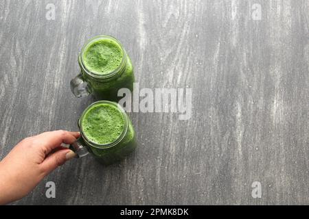 Grüner Saft aus Gemüse wie Gurke, Zitrone, Spinat, Mangold, Sellerie, serviert in einem Glasbecher für ein gesundes, nahrhaftes Frühstück Stockfoto