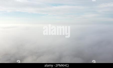 Himmel Wolken Nebel. Luftaufnahme von blauem Himmel und weißen Wolken. Blick auf Nebel von oben und Himmel mit Wolken. Nebelbewegung über der Stadt. Blick von oben. Abstrakter natürlicher Hintergrund. Naturkulisse. Stockfoto