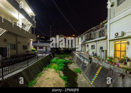 Ein kleiner Bach durch das ruhige japanische Viertel auf Awaji Island bei Nacht Stockfoto