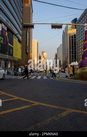 Straßenfotografie in der Metropole Seoul, Südkorea. Genießen Sie den Sonnenuntergang, der die Straßen beleuchtet und die Menschen, die entlang dieser Straße gehen. Stockfoto