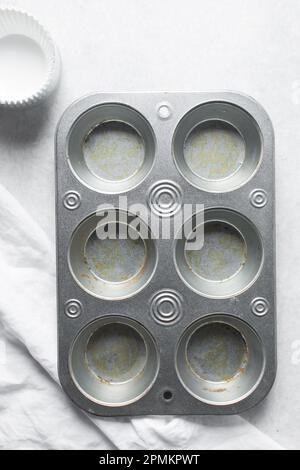 Silberne Cupcake-Pfanne zum Zubereiten von Cupcakes und Muffins mit weißen Einlagen. Sechs Muffin-Pfanne Stockfoto