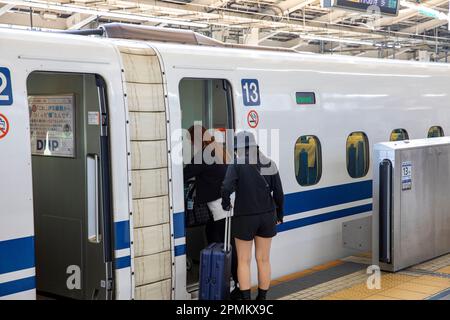 April 2023 zwei weibliche Passagiere steigen am Bahnhof Tokio in Japan, Asien, in den Shinkansen-Hochgeschwindigkeitszug ein Stockfoto