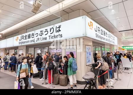 Bahnhof Tokio, 2023. April, Reisenden, die sich anstellen, um Zugfahrkarten für Shinkansen-Schnellzüge und JR-Fahrkarten am Ticketschalter in Japan zu kaufen Stockfoto