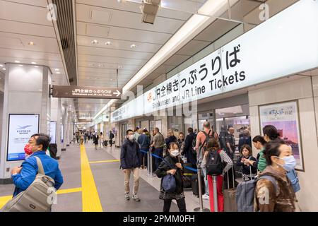 Bahnhof Tokio, 2023. April, Reisenden, die sich anstellen, um Zugfahrkarten für Shinkansen-Schnellzüge und JR-Fahrkarten am Ticketschalter in Japan zu kaufen Stockfoto