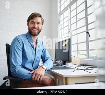 Der Erfolg gehört Ihnen. Ein attraktiver Designer, der in die Kamera lächelt. Stockfoto
