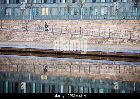 Berlin, Deutschland. 14. April 2023. Ein Passant geht morgens am Ufer der Spree entlang. Die Aussichten für das kommende Wochenende in Berlin sind düster. Es bleibt grau und regnerisch. Kredit: Christoph Soeder/dpa/Alamy Live News Stockfoto