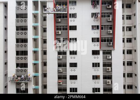 Große Aussicht auf 2 Gondelaufzüge, die vor einem Block hängen, professionelle Maler, die das Gebäude mit einem frischen Anstrich bemalt haben, Singapur. Stockfoto