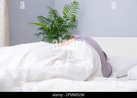 Ein bärtiger junger Mann schläft in einem gemütlichen Bett. Ich schlafe gern. Gesunder Schlaf eines Mannes in einem frischen weißen Bett. Stockfoto