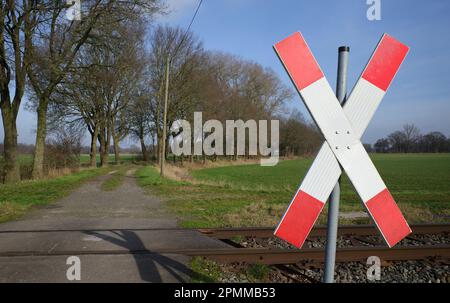 Eine Landstraße kreuzt eine Eisenbahn. Eine unbewachte Kreuzung in Deutschland Stockfoto