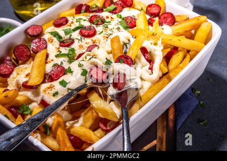 Pizzaladung pommes frites. Hausgemachte Pepperoni und Käse Pizza Pommes frites. Im Ofen gebackene pommes frites, Kartoffelauflauf mit Käse, Salami und Salami Stockfoto