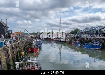 Kleine Fischerboote, die am Hafen von Whitstable, North Kent Coast, England, Großbritannien, gefesselt sind Stockfoto