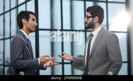 Zwei Geschäftsmänner, die bei einem Meeting im Büro über das Projekt sprechen. Stockfoto