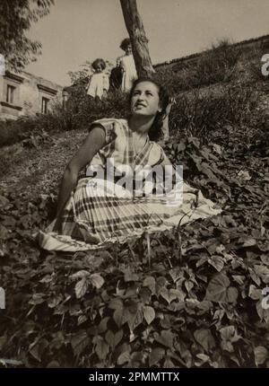 Rom, Italien Mai 1951: Atemberaubende junge Frau, die in den 1950er Jahren die Natur auf einer friedlichen Wiese genießt. Stockfoto