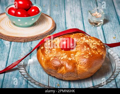 Traditionelles Osterbrot, griechisches Tsoureki und rote Eier auf einem Tisch Stockfoto