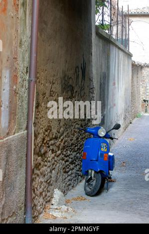 Casciano di Murlo, Italien, 18.07.2010. In der engen Gasse steht ein blauer Roller. Stockfoto