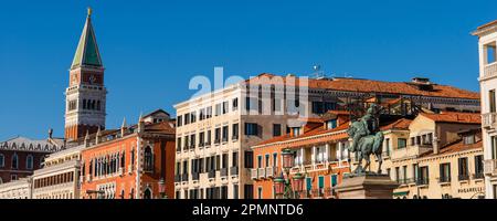 Die Dächer historischer Gebäude entlang der Uferpromenade Riva degli Schiavoni mit der Statue und dem Denkmal für Victor Emmanuel II. Und der spi... Stockfoto