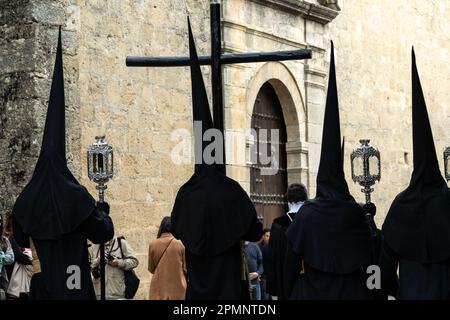 Die Buhnen tragen schwarze, spitz zulaufende Kapuzen und tragen ein Holzkreuz aus St. Mary Major Church während einer Heiligen Woche oder Semana Santa Prozession am Karfreitag, 6. April 2023 in Ronda, Spanien. Ronda, die sich im 6. Jahrhundert v. Chr. niedergelassen hat, hält seit über 500 Jahren Heilige Woche-Prozessionen ab. Kredit: Richard Ellis/Richard Ellis/Alamy Live News Stockfoto