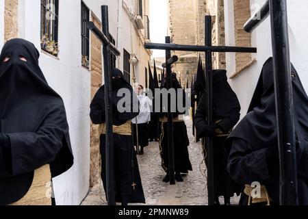 Die Buhnen tragen schwarze Kapuzen und tragen Holzkreuze aus der St. Mary Major Church während einer Heiligen Woche oder Semana Santa Prozession am Karfreitag, 6. April 2023 in Ronda, Spanien. Ronda, die sich im 6. Jahrhundert v. Chr. niedergelassen hat, hält seit über 500 Jahren Heilige Woche-Prozessionen ab. Kredit: Richard Ellis/Richard Ellis/Alamy Live News Stockfoto