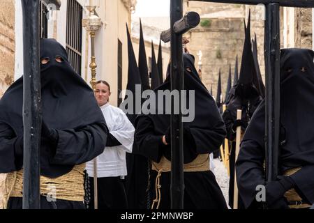 Die Buhnen tragen schwarze Kapuzen und tragen Holzkreuze aus der St. Mary Major Church während einer Heiligen Woche oder Semana Santa Prozession am Karfreitag, 6. April 2023 in Ronda, Spanien. Ronda, die sich im 6. Jahrhundert v. Chr. niedergelassen hat, hält seit über 500 Jahren Heilige Woche-Prozessionen ab. Kredit: Richard Ellis/Richard Ellis/Alamy Live News Stockfoto