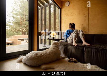 Eine Frau mit ihrem Hund im Haus auf der Natur Stockfoto