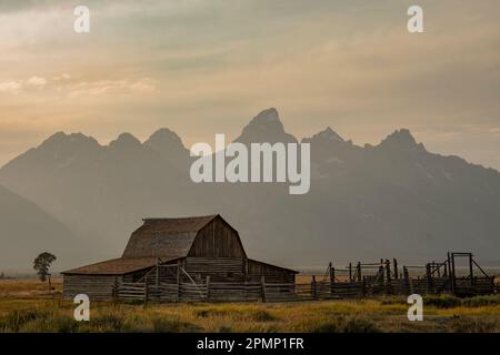 Scheune auf historischem Gehöft mit Teton Range im Hintergrund, Grand Teton National Park, Wyoming, USA; Wyoming, Vereinigte Staaten von Amerika Stockfoto