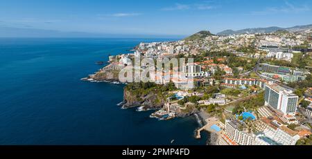 Panoramablick aus der Vogelperspektive auf den Lido in Funchal, den Palast von Belmond Reid, das Maritimo-Stadion, natürliche Pools, das Blaue Meer und Hotels Stockfoto