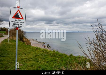 PRODUKTION - 13. April 2023, Schleswig-Holstein, Travemünde: Ein Schild mit der Aufschrift "Vorsicht, steile Ufer abbrechen, auf eigene Gefahr einfahren" steht am Brodtener Steilufenufer. (Zu dpa: Abbrechkante rückt näher - Haus Seeblick steht fest über der Ostsee) Foto: Frank Molter/dpa Stockfoto