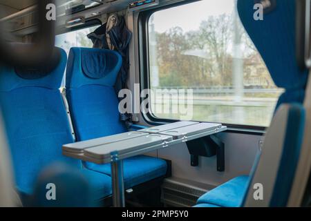 Innenausstattung eines modernen Intercity-Expresszugs. Rückansicht der breiten, komfortablen Sitze in Reihe beim Eisenbahntransport. Leerer Salon, keine Passagiere. Reisen Stockfoto