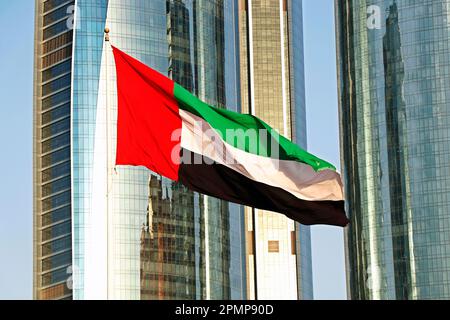 vereinigte arabische emirate (vae) die Nationalflagge weht am Himmel vor hohen Gebäuden in abu dhabi Stockfoto