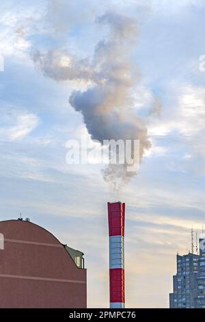 Weißer Rauch aus dem großen Schornstein in der Heizungsanlage Stockfoto