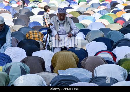 Srinagar, Indien. 14. April 2023. Ein älterer Mann betet, während er am letzten Freitag des Ramadan in Srinagar auf einem Stuhl im Hazratbal-Schrein sitzt. Moslems auf der ganzen Welt boten ihre letzten Freitaggebet des heiligen Monats Ramadan. Dieser Tag wird vor Eid al-Fitr gefeiert, einem der wichtigsten Festivals der muslimischen Gemeinde. Kredit: SOPA Images Limited/Alamy Live News Stockfoto