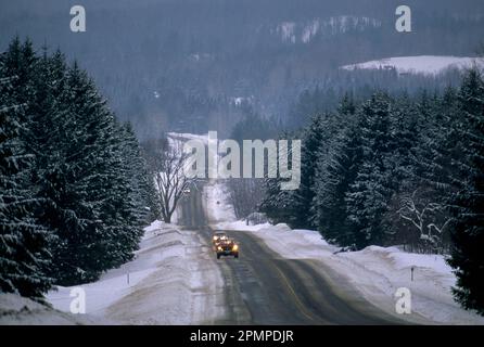 Autos auf einer verschneiten Autobahn in den Bergen; Stowe, Vermont, Vereinigte Staaten von Amerika Stockfoto