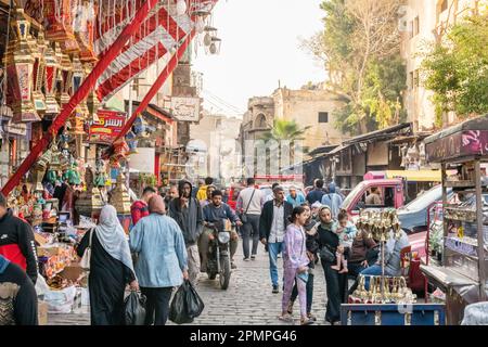 Menschen gehen durch einen geschäftigen Khan el-Khalil Markt Basar im islamischen Kairo in Kairo, Ägypten Stockfoto