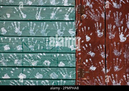 Handabdrücke schmücken die bemalten Holzverkleidungen an der Außenseite eines Hauses, Jamaika, Westindien. Stockfoto