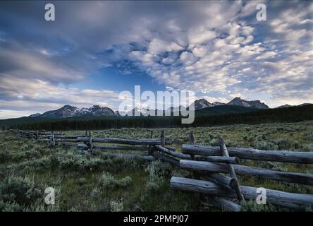 Die Sawtooth Range, ein Teil der Rocky Mountains, ist eine Kulisse für einen Split-Rail-Zaun in Idaho, Vereinigte Staaten von Amerika Stockfoto