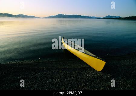 Gelbes Kanu am Ufer eines ruhigen Gewässers, Kluane Lake, Kluane National Park, Yukon, Kanada; Yukon, Kanada Stockfoto