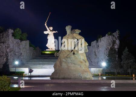 WOLGOGRAD, RUSSLAND - 19. SEPTEMBER 2021: Die skulpturelle Komposition „Stand to Death“ und das Denkmal der „Vaterlandrufe“ in der Nachtlandschaft. Stockfoto